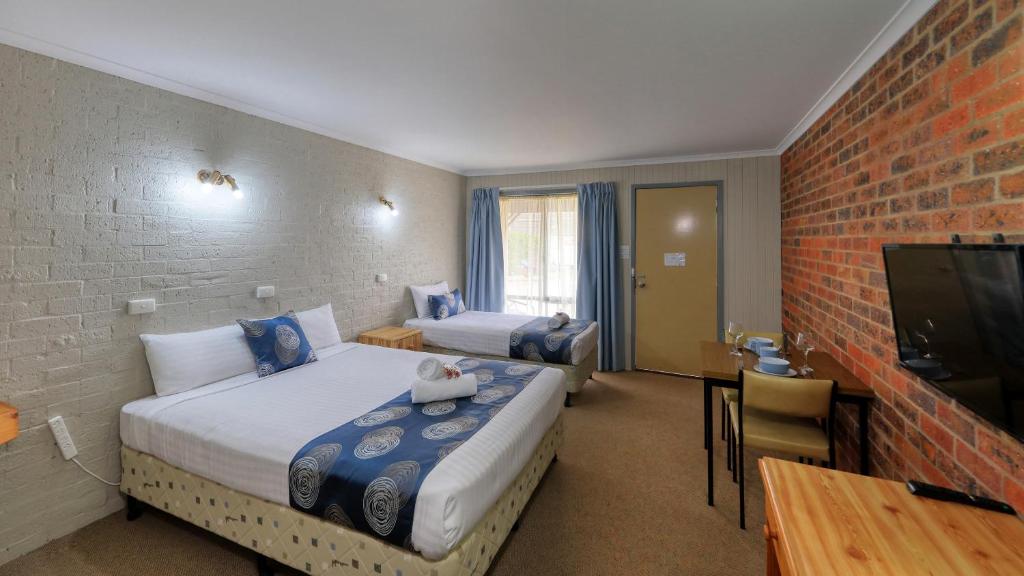una camera d'albergo con due letti e una televisione di Barham Riverland Motel a Barham