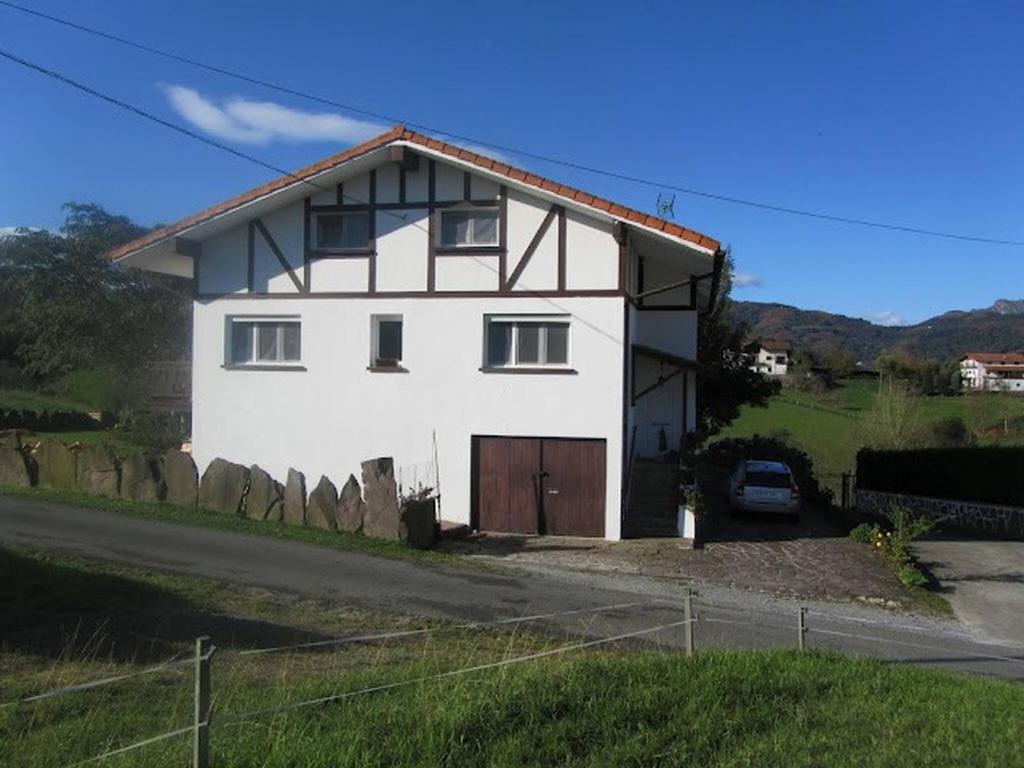 ein weißes Haus mit einer Garage an der Straßenseite in der Unterkunft Only 30 Kms From San Sebastian in Bera