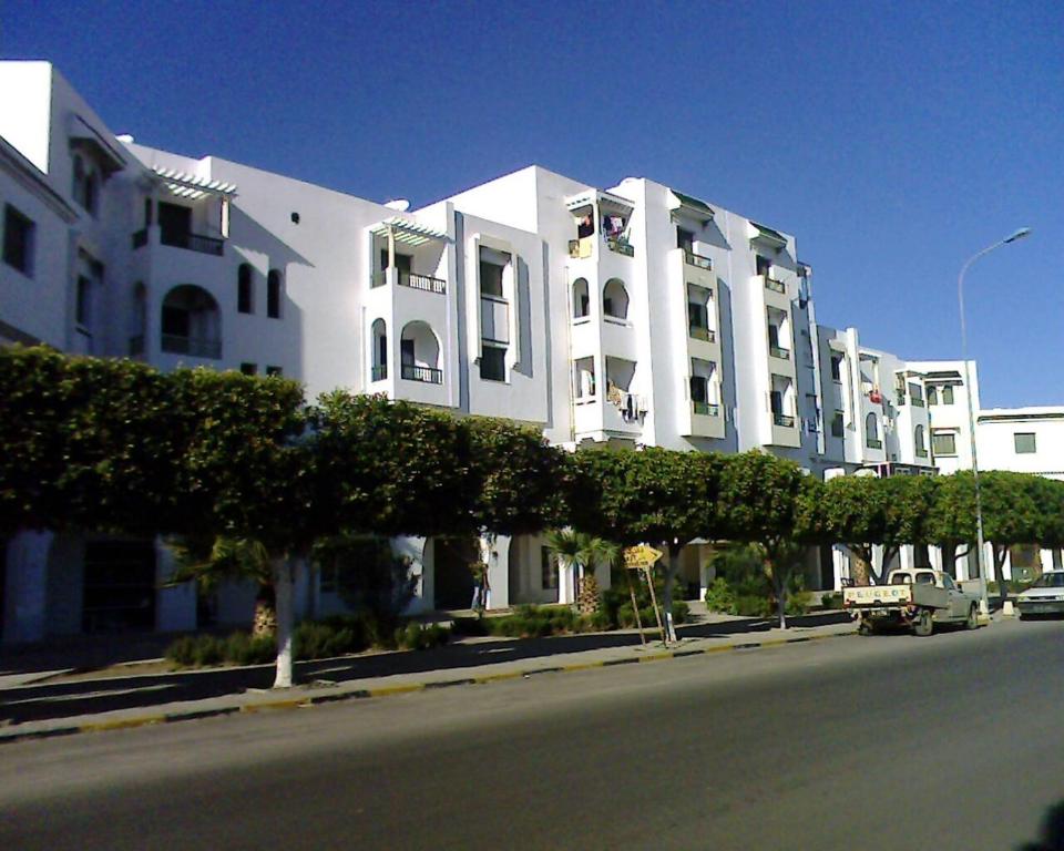 a large white building on the side of a street at Excellente Appartement Entre Monastir Et Sousse in Sahline