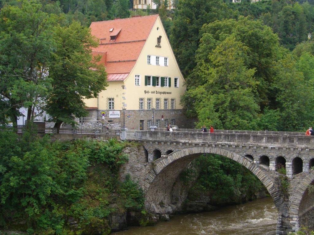 a bridge over a river in front of a building at Hotel Alpin Murau in Murau