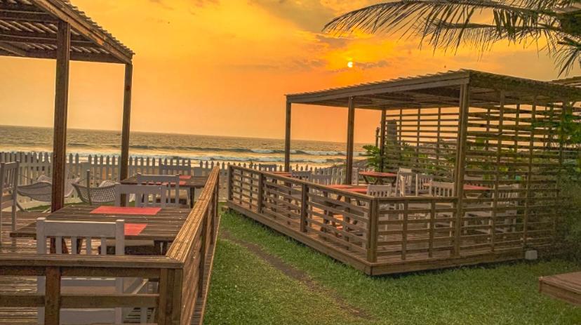 Fahrenheit Hotels & Resorts في باغا: شاطئ به طاولات وكراسي والمحيط