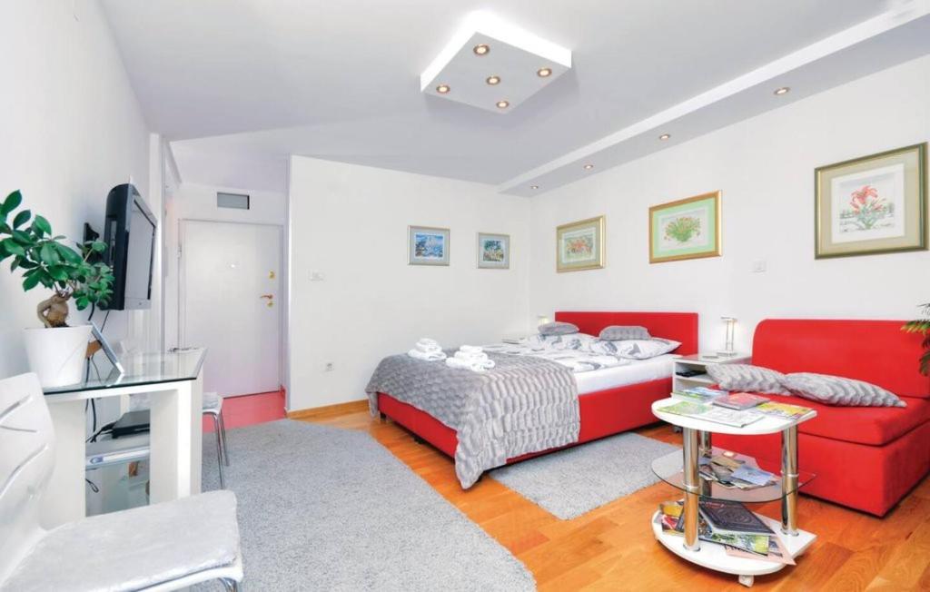 a bedroom with a red bed and a red couch at Apartments Asja- city view in Zagreb