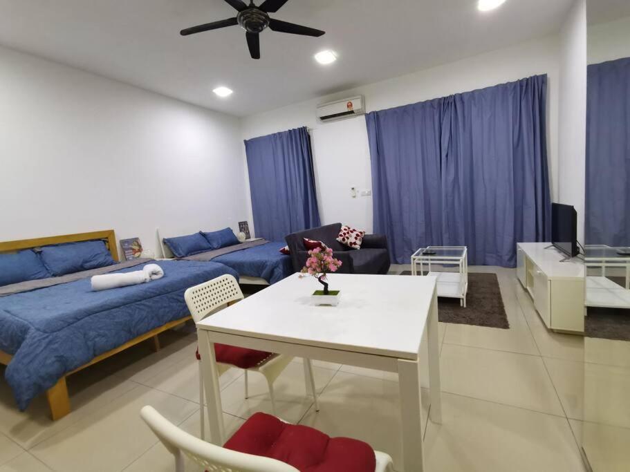 a living room with a bed and a table with chairs at G-mat Staycation free WiFi & Netflix in Cyberjaya