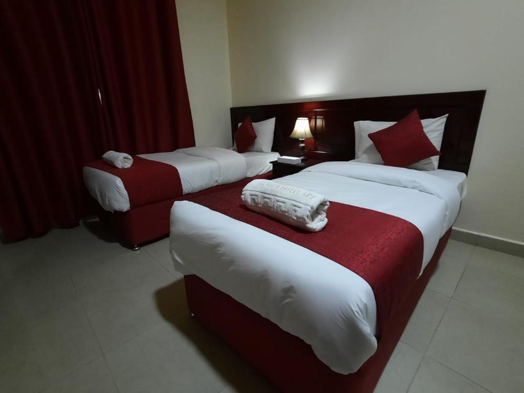 a hotel room with two beds and a couch at Al Reem Hotel Apartments in Sharjah