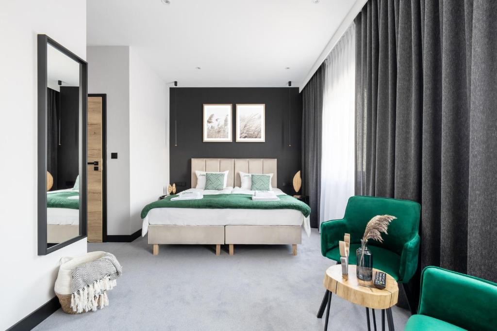 sypialnia z łóżkiem i 2 zielonymi krzesłami w obiekcie Hotel Natura w mieście Słońsk