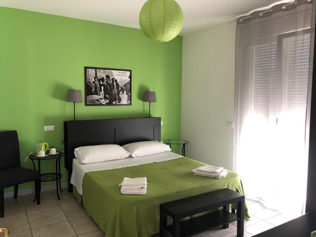a green bedroom with a bed and a chair at Il Pozzo in San Benedetto del Tronto