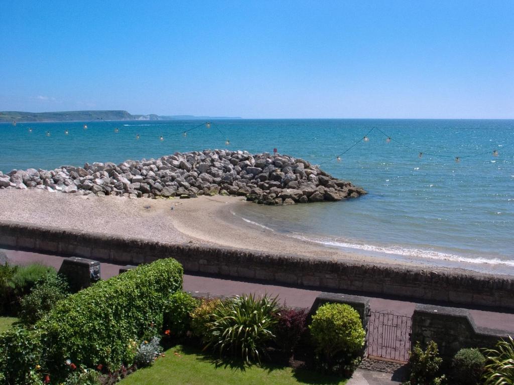 a beach with a bunch of rocks in the water at Weymouth Bay Apartment A in Weymouth