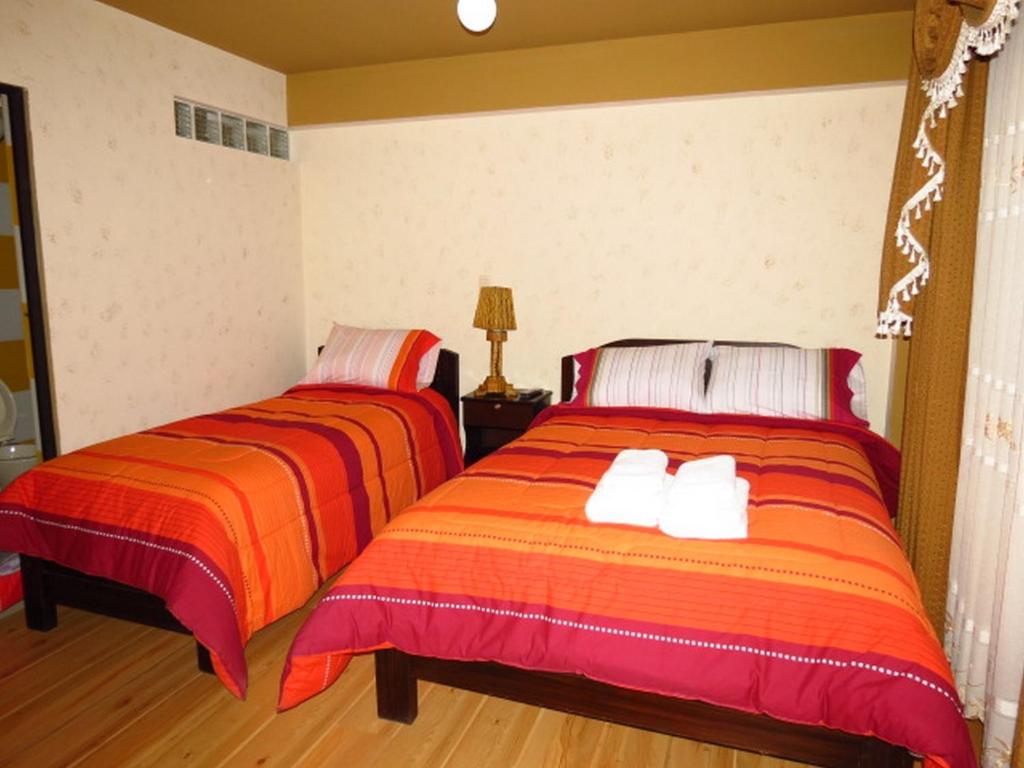 two beds sitting next to each other in a room at Hotel Jumari in Uyuni