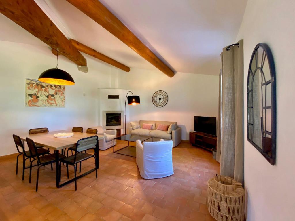 a living room with a table and chairs and a couch at Domaine Perréal Les Gîtes in Gargas