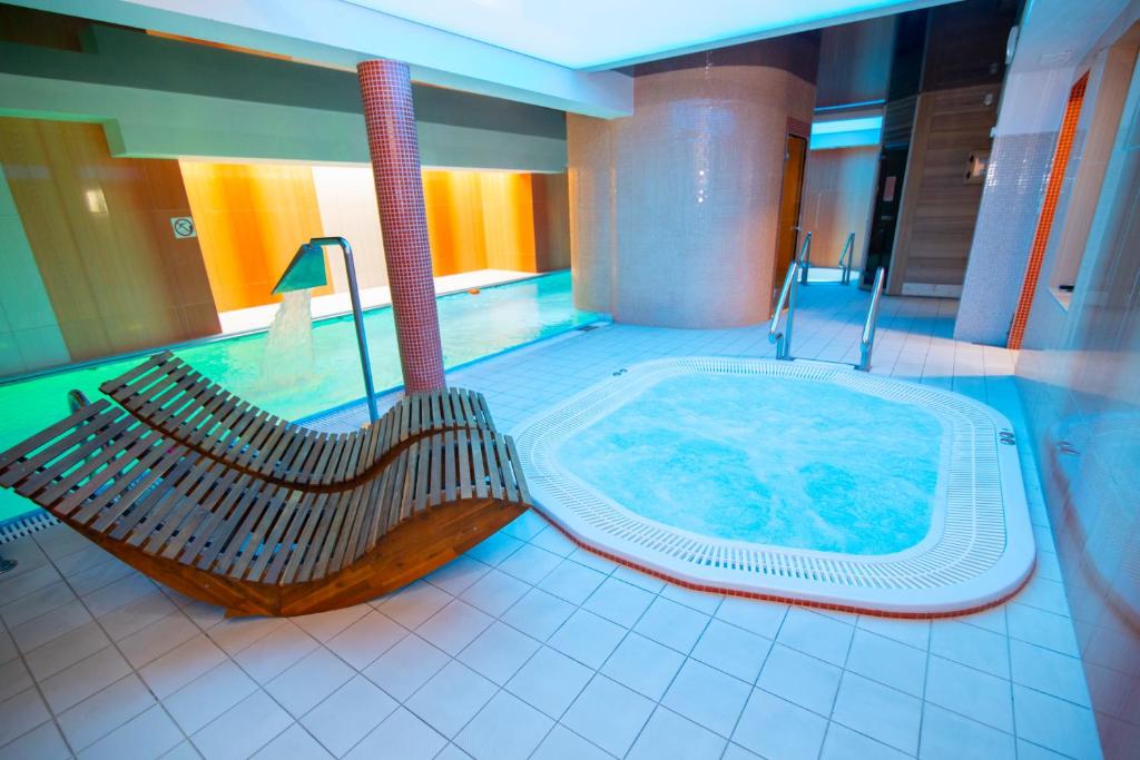 a swimming pool with a hot tub and a swing at Paula Wellness & SPA in Pobierowo