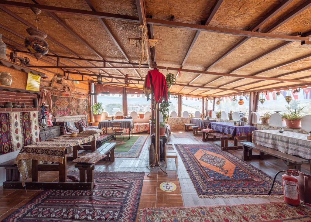 a living room with tables and rugs on the floor at Anz Guest House Pansiyon in Selcuk