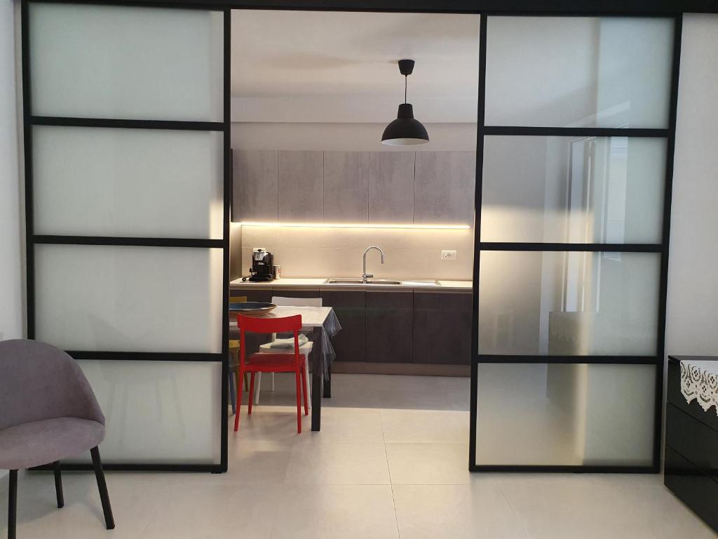 een keuken met glazen deuren en een rode stoel bij Casa consiglia in Ostuni
