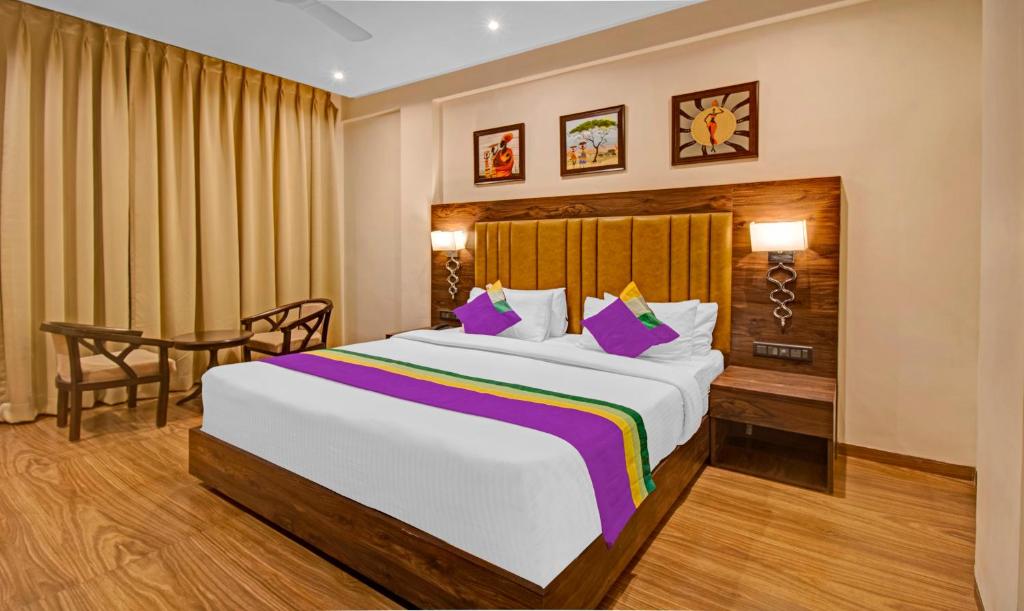ein Hotelzimmer mit einem großen Bett und einem Tisch in der Unterkunft Treebo Tryst Median Inn in Nagpur