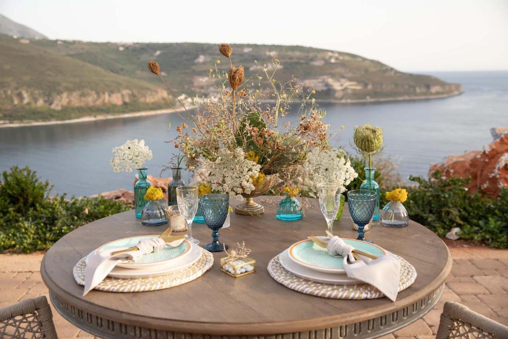 a table with plates and vases on it with a view at Akrolithi Boutique Hotel & Suites in Oitylo
