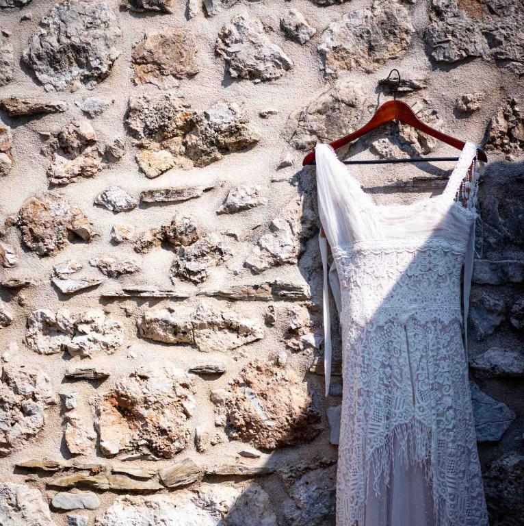 a white dress hanging on a stone wall at Akrolithi Boutique Hotel & Suites in Oitylo