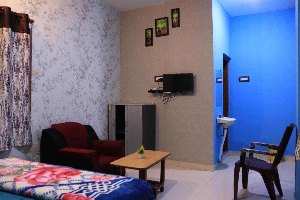 um quarto com uma cama, uma mesa e uma televisão em Pinetree Residency em Kodaikānāl