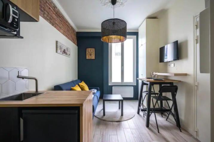Il comprend une cuisine et un salon avec une table et des chaises. dans l'établissement CMG Cosy Studio- 2P - Nation - Voltaire, à Paris