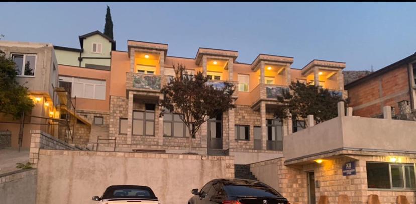 two cars parked in front of a large building at Motel Nur NS in Mostar