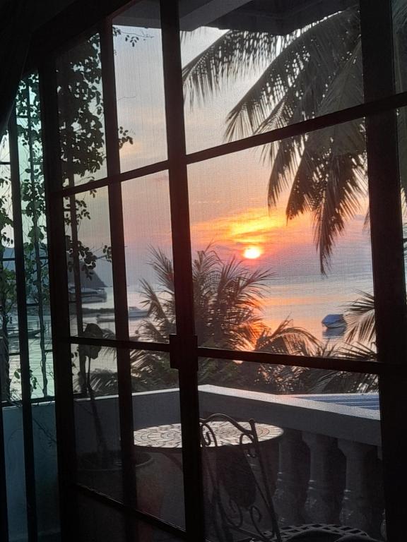 a view of a sunset from a window at Tea Moon Beach House in Thongsala