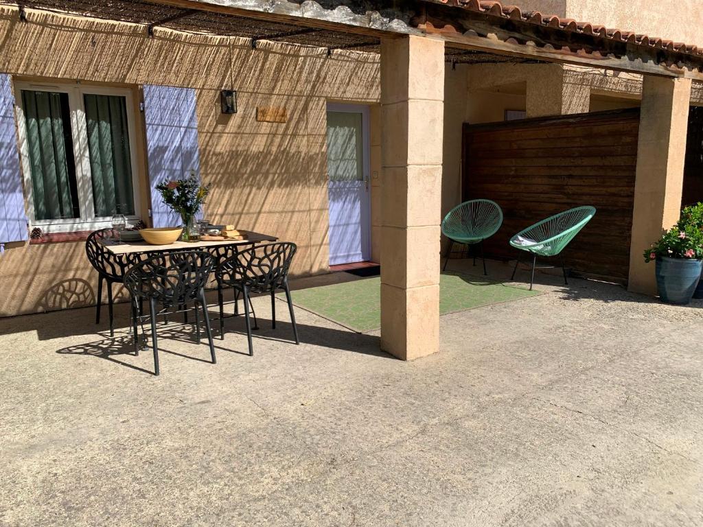 a patio with a table and chairs on a patio at Résidence Les Sources in Saint-Rémy-de-Provence