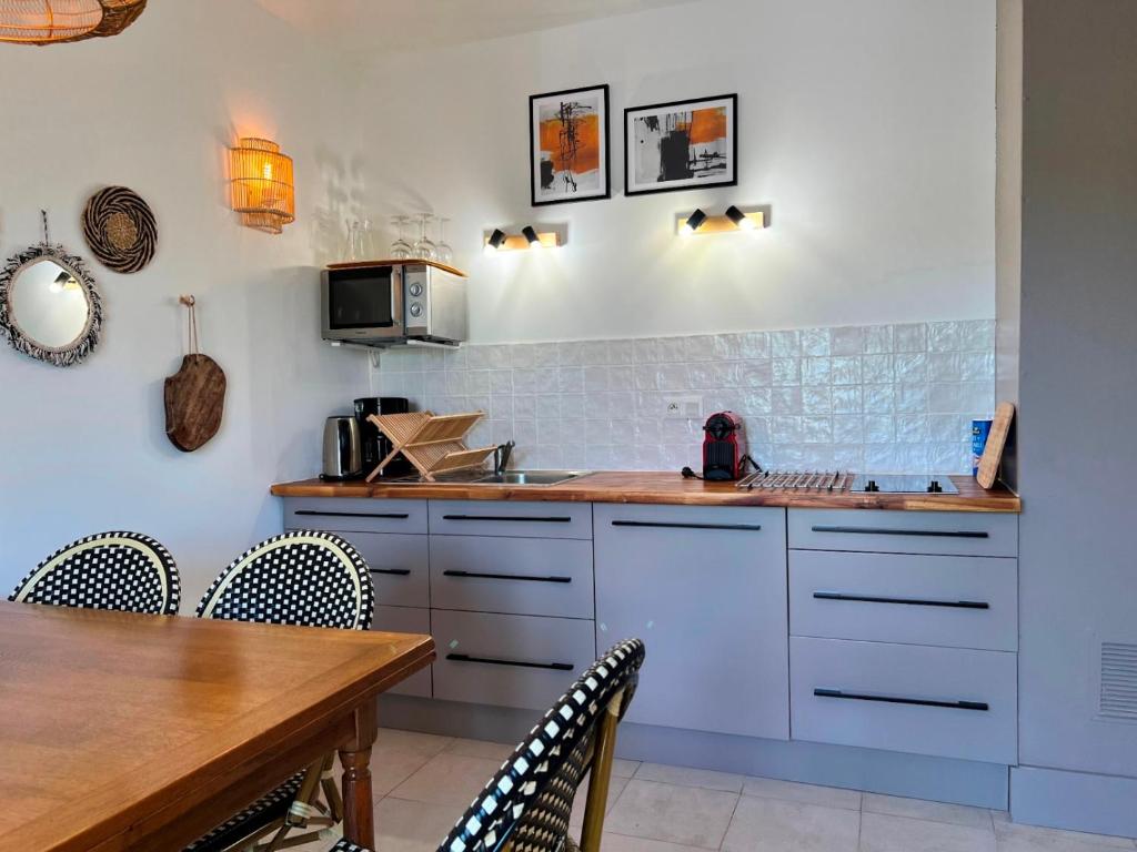 a kitchen with a table and a counter top at Résidence Les Sources in Saint-Rémy-de-Provence