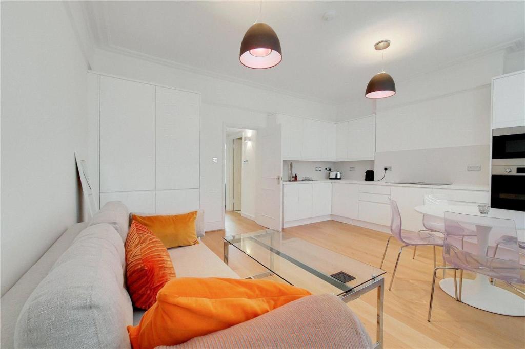 a living room with a couch and a table at Paddington Gardens in London