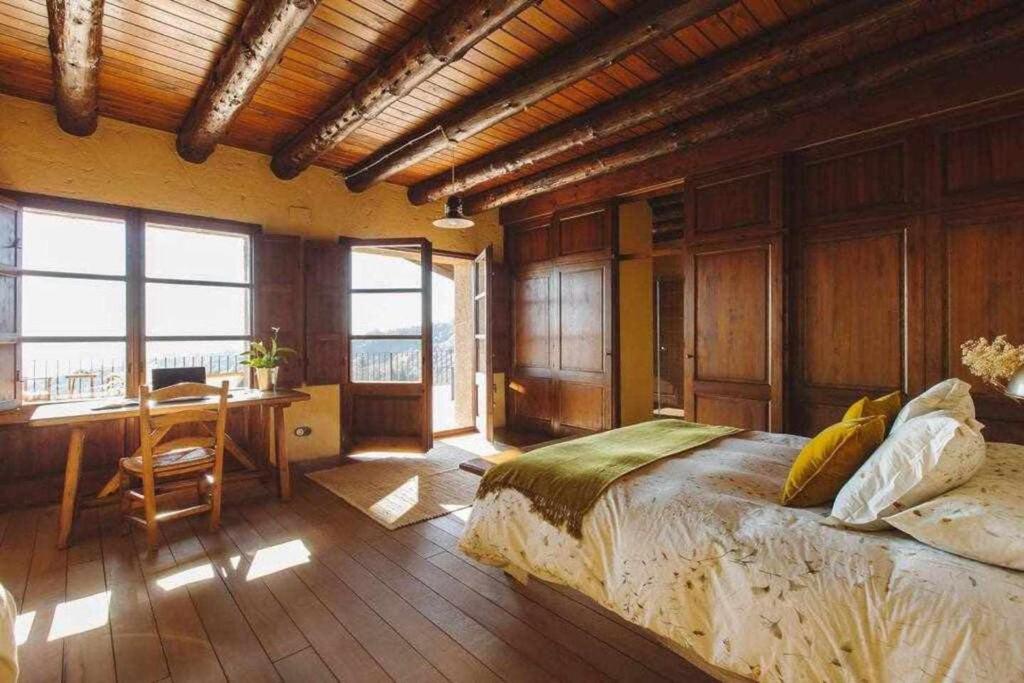 um quarto com uma cama e uma secretária num quarto em Mas Redortra Excepcional masía del SXV con vistas al Montseny em Sant Pere de Torelló