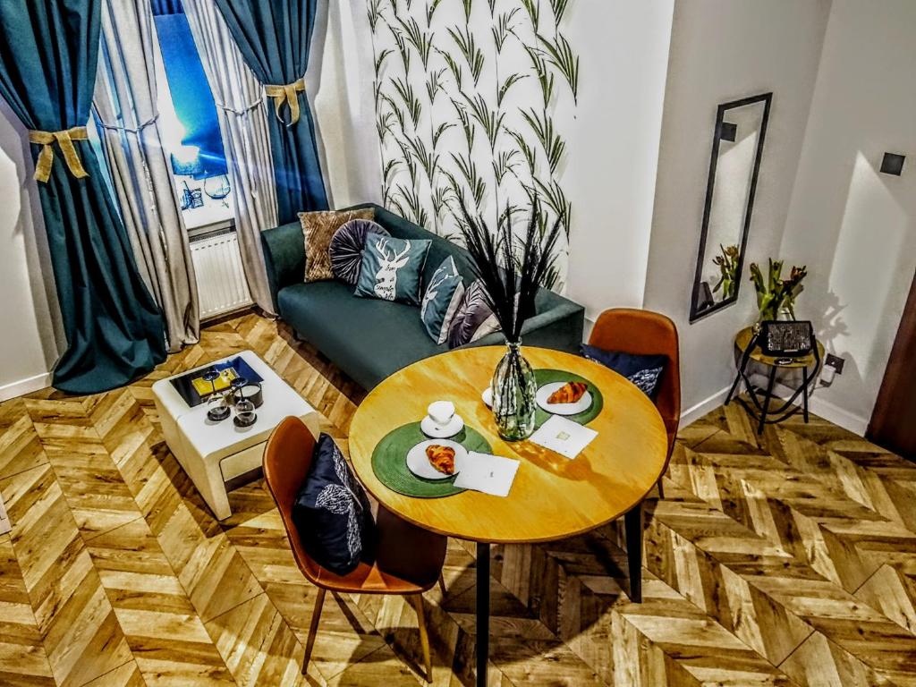 una sala de estar con una mesa y un sofá en EvitaDeLux Słowackiego 50mGaleria Katowice, en Katowice