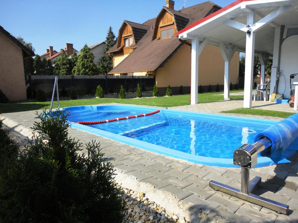 uma piscina com um escorrega num quintal em Villa Ani Hajduszoboszlo em Hajdúszoboszló