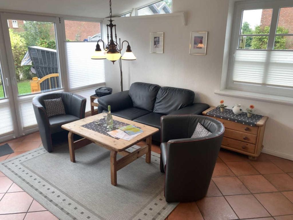 un soggiorno con divano, sedie e tavolo di Am Kurhaus 11b a Nordstrand