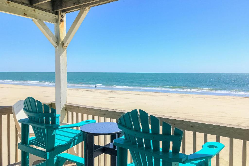 two chairs and a table on the beach at OIB28 Summer Sands in Ocean Isle Beach