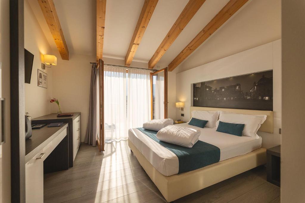 una camera da letto con un letto e una grande finestra di Hi Hotels Trento - Wellness & Spa Adults Only a Trento