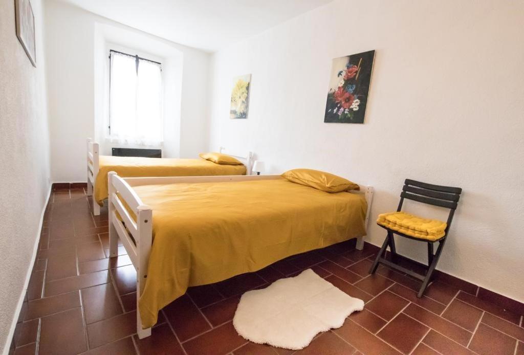 a bedroom with two beds and a chair in it at CARMEN HOME in Grancia