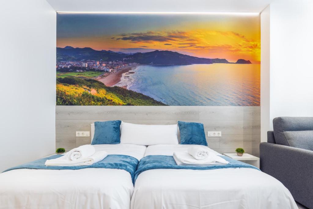 1 dormitorio con una gran pintura de playa en Santa Marina Apartamentuak Zarautz, en Zarautz