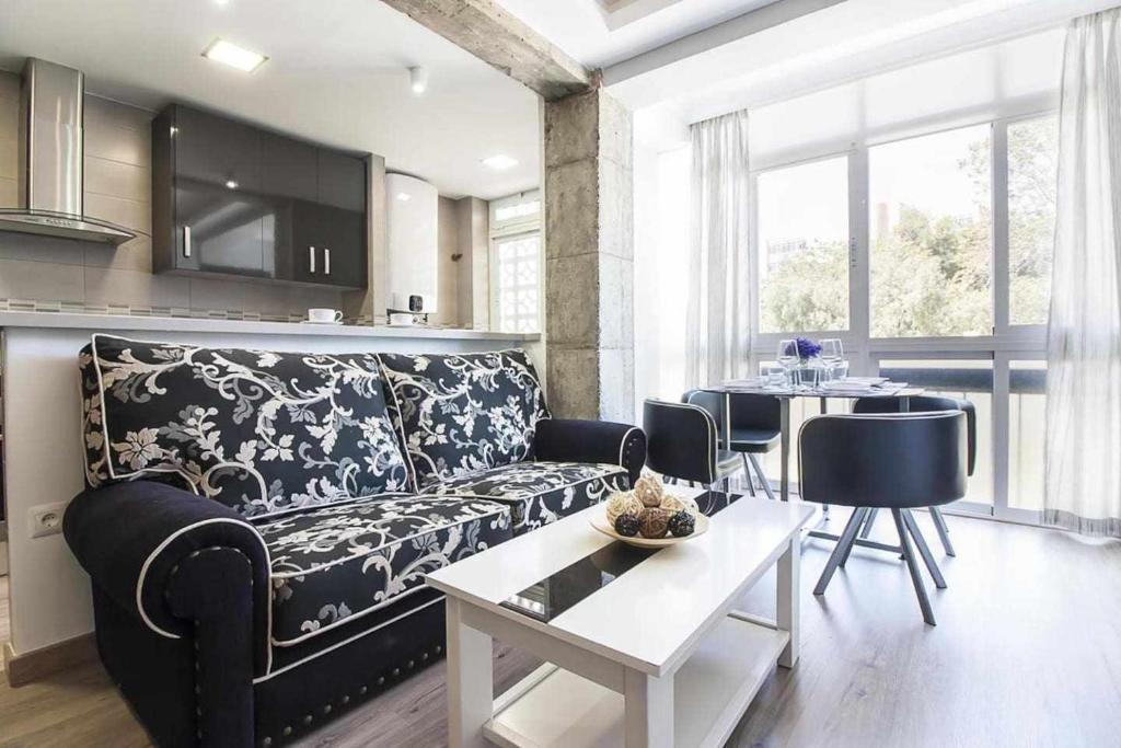 salon z kanapą i stołem w obiekcie Cerca de Picasso y la Merced, Apartamento renovado w Maladze