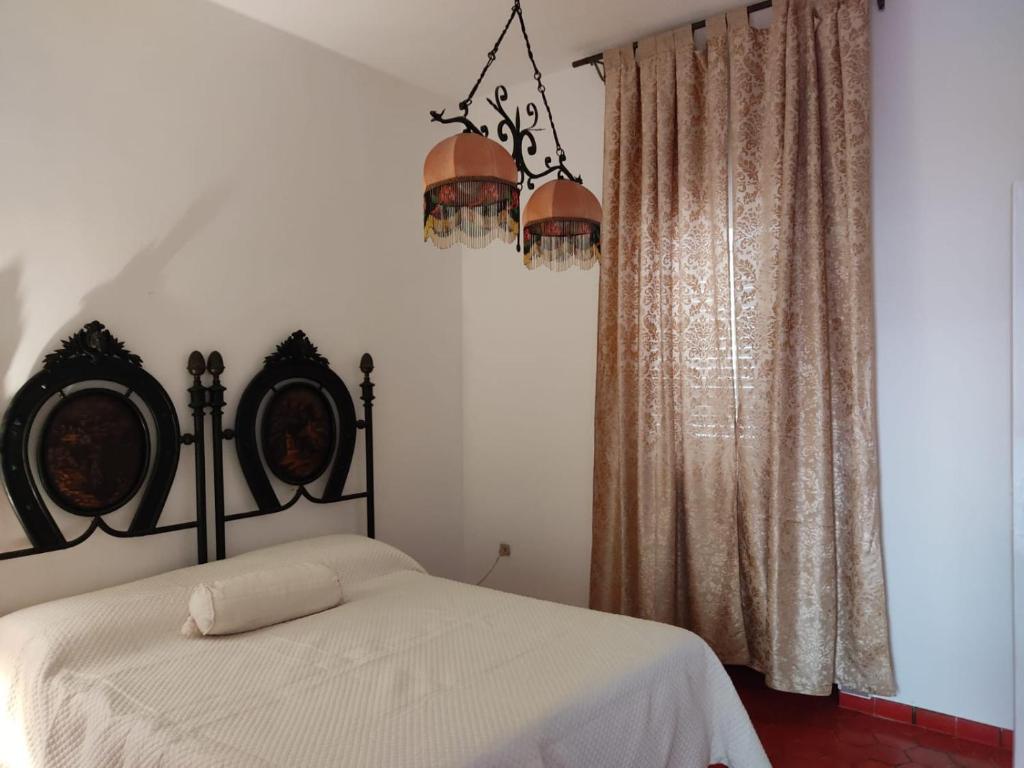 1 dormitorio con cama y lámpara de araña en Villa Maria en Villanova di Ostuni