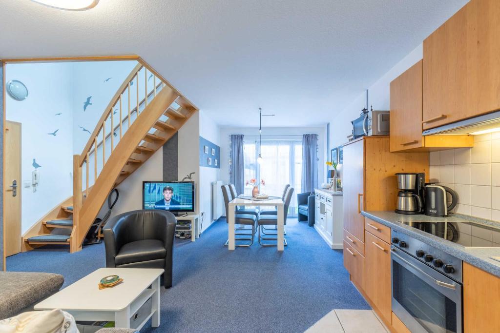 a kitchen and living room with a table and a staircase at Haus Seewind Wohnung 3 in Cuxhaven