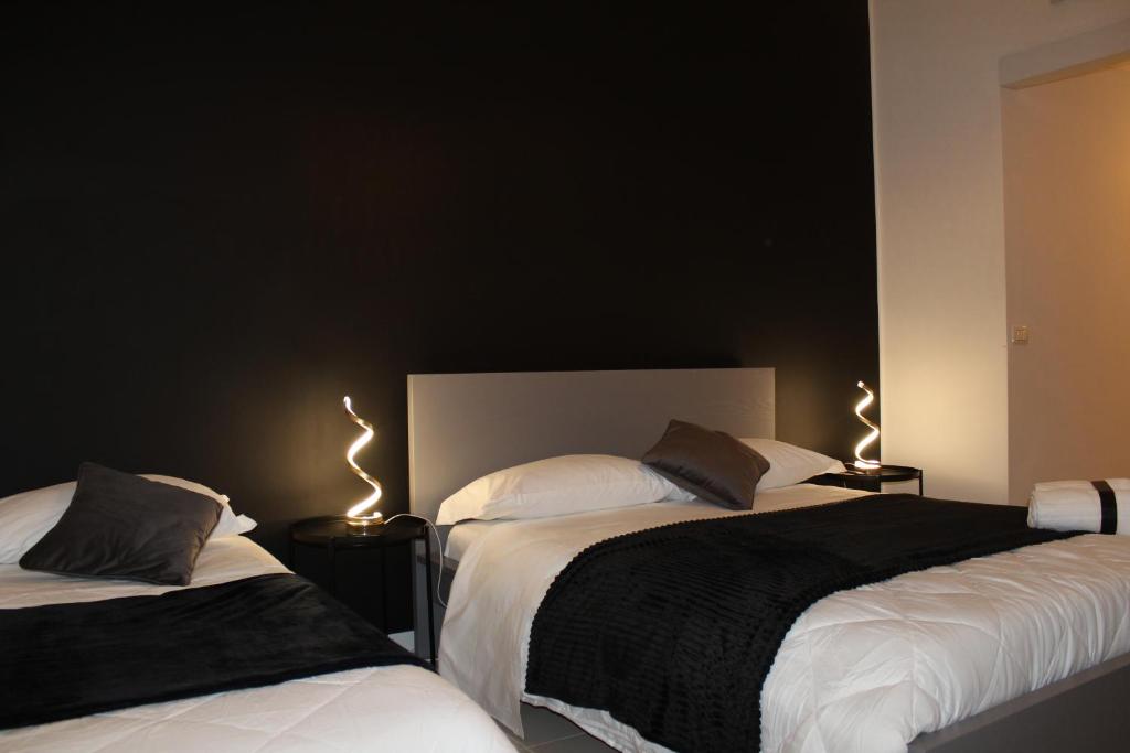 sypialnia z 2 łóżkami z oświetleniem w obiekcie Essenza del Tempo Inn w Katanii