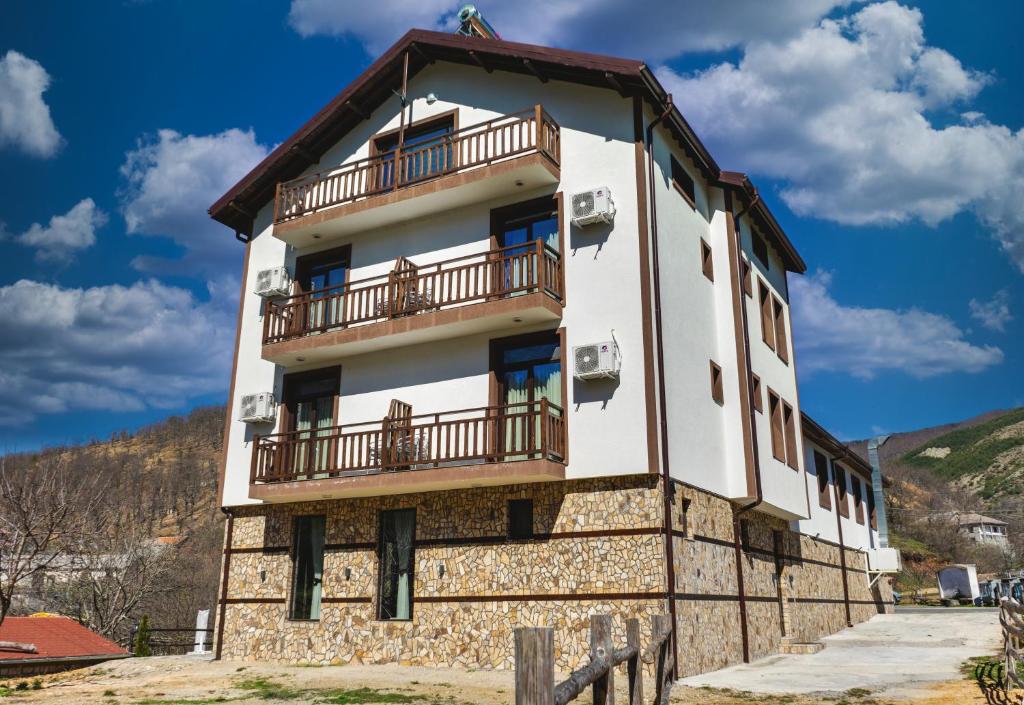 a building with a balcony on top of it at Family Hotel LILIUM in Kirkovo