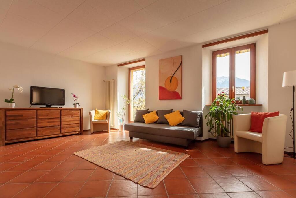 sala de estar con sofá y TV en Casa al Sole - Bellissimo appartamento con terrazza e vista lago en Minusio