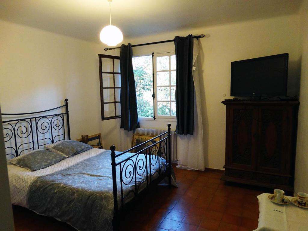 1 dormitorio con 1 cama y TV de pantalla plana en Chambre dans propriété La Croix du Sud, en Le Pradet