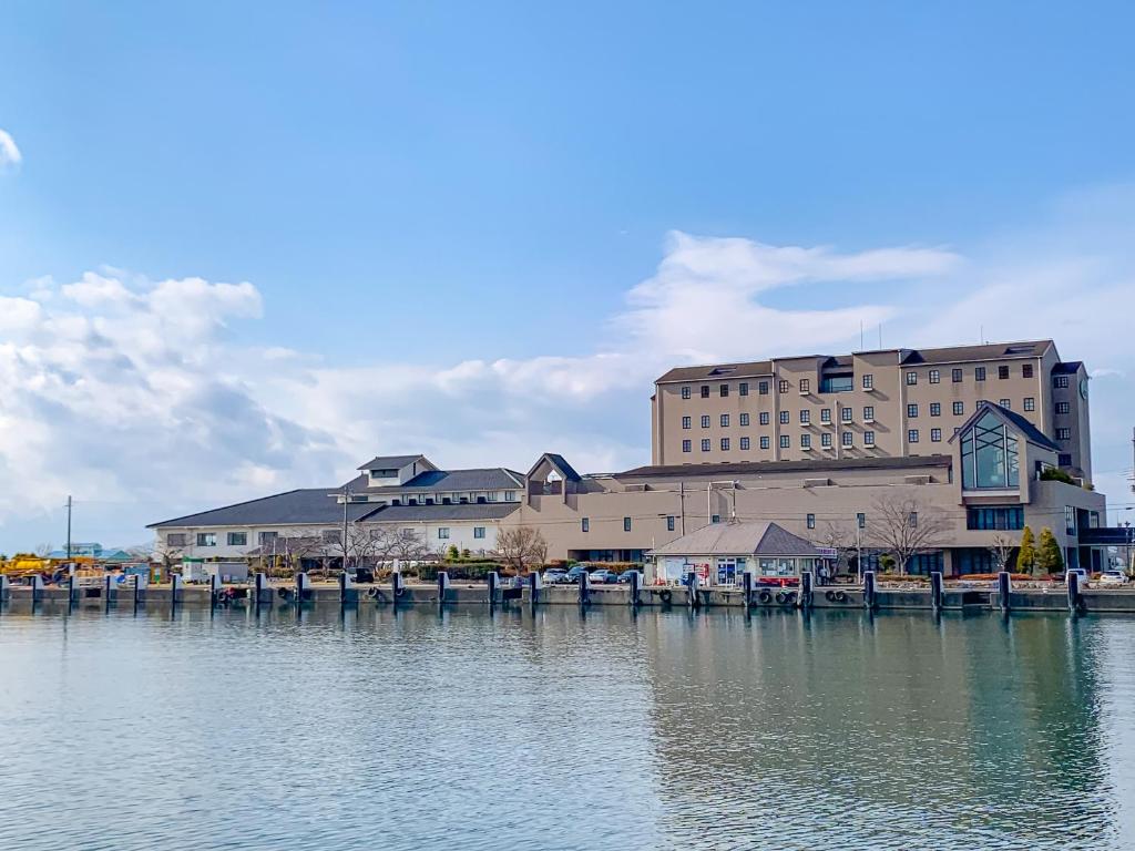 a large building sitting next to a body of water at Kitabiwako Hotel Grazie in Nagahama