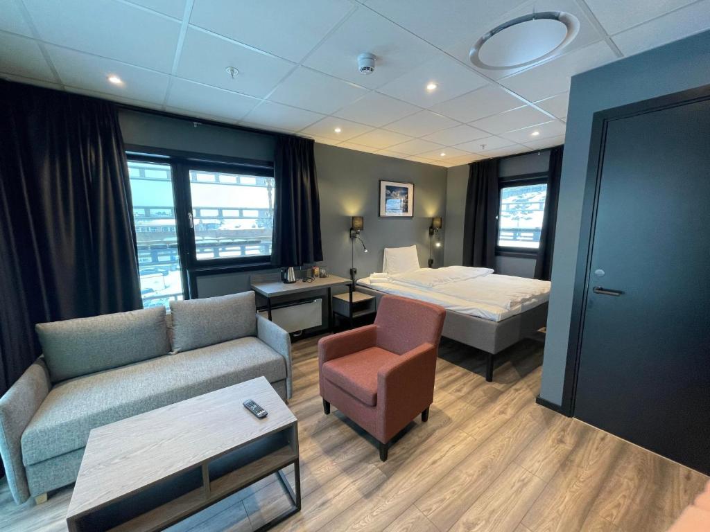 Arctic Sea Hotel في هامرفست: غرفة في الفندق مع أريكة وسرير