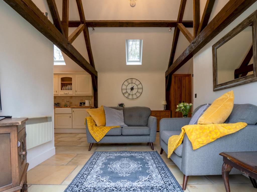 a living room with two chairs and a table at Pass the Keys Secluded 2 bedroom cottage in scenic Aston Magna in Moreton in Marsh