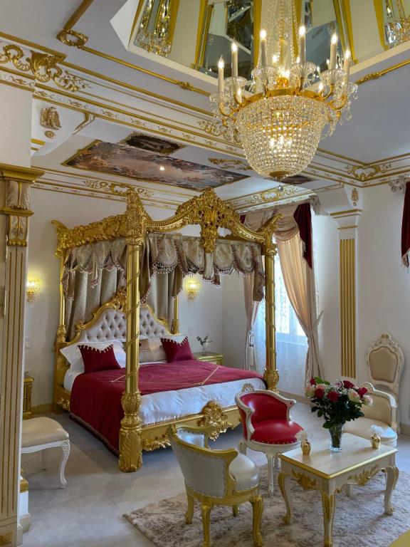 um quarto com uma cama de dossel e um lustre em Suite Impériale Église du Couvent em Narbonne