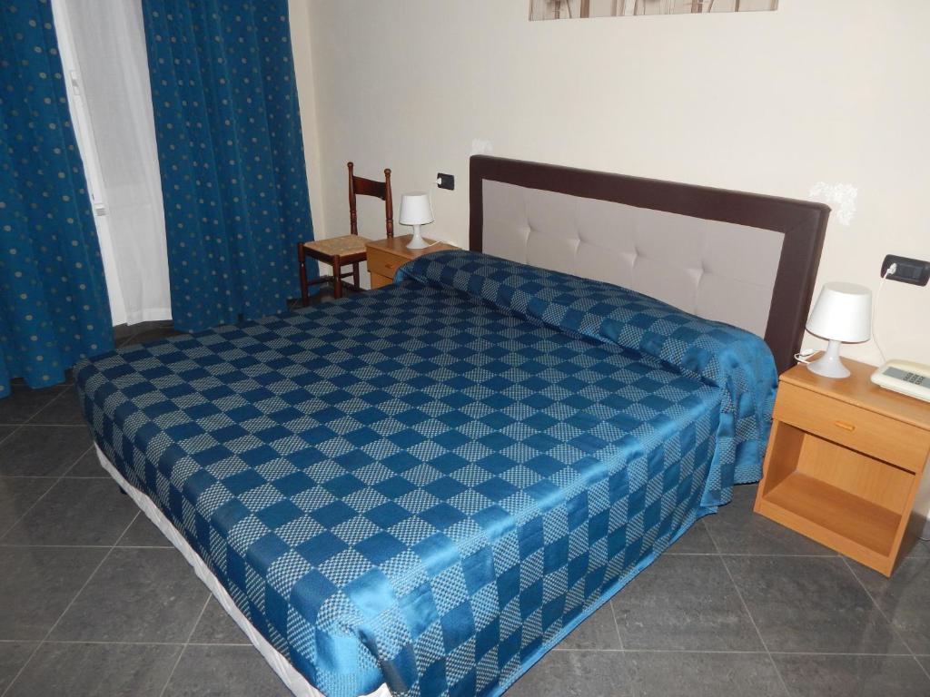 um quarto com um edredão azul numa cama em albergo massimo em Loano