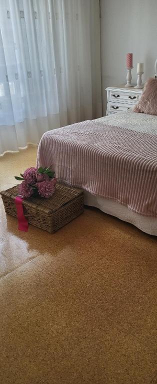 a bedroom with a bed and a basket with flowers on it at Olimphya in Ourense
