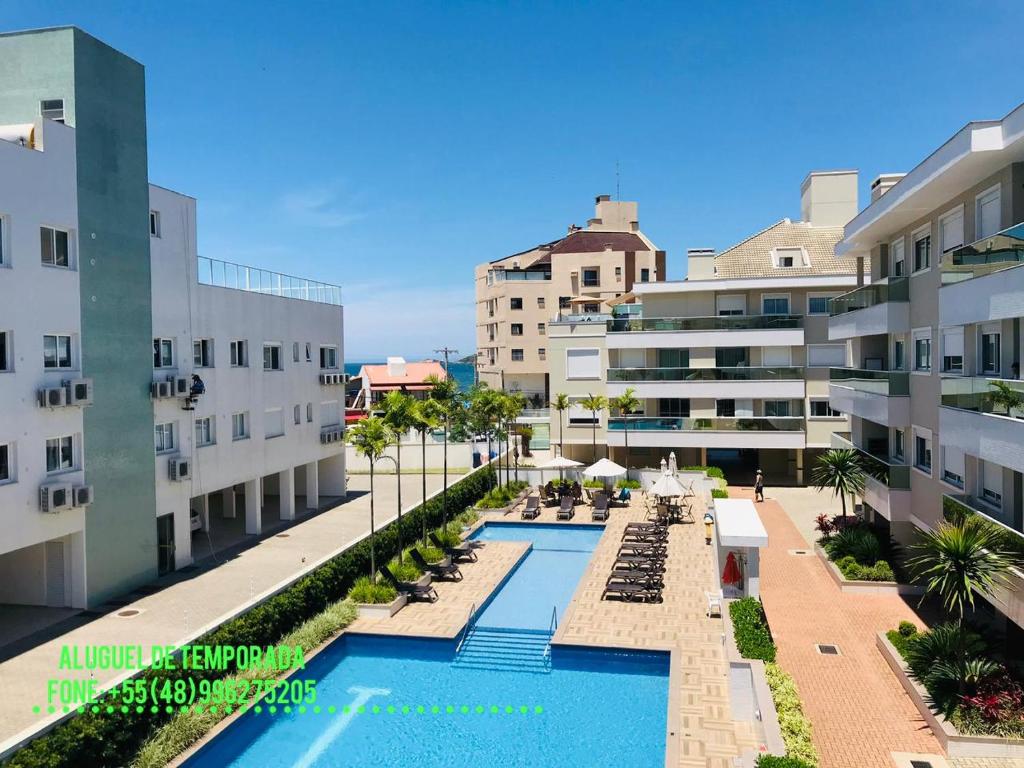 - une vue sur la piscine entre deux bâtiments dans l'établissement Apartamento de frente para Piscina, com vista para o mar, à Florianópolis
