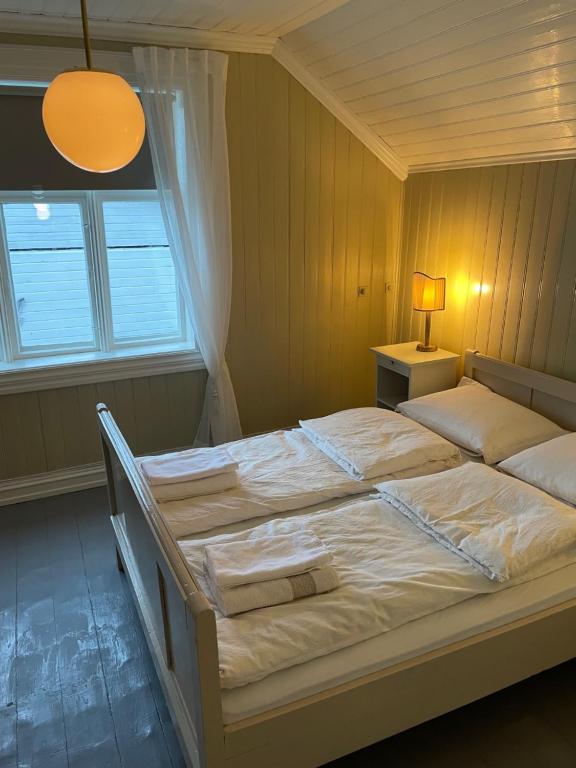 un letto grande in una camera da letto con finestra di 2. etg i Dampskipsbrygga, Lødingen havn a Lødingen