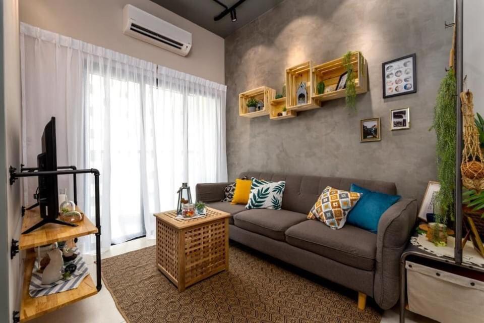 ein Wohnzimmer mit einem Sofa und einem TV in der Unterkunft Cozy 2 bedrooms 4 pax Menjalara Near Desa Park City in Kuala Lumpur